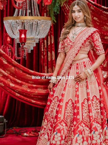 A stunning portrait of the bride in her red lehenga. Her mehendi-adorned arms add a layer of tradition and artistry to her regal and elegant look.