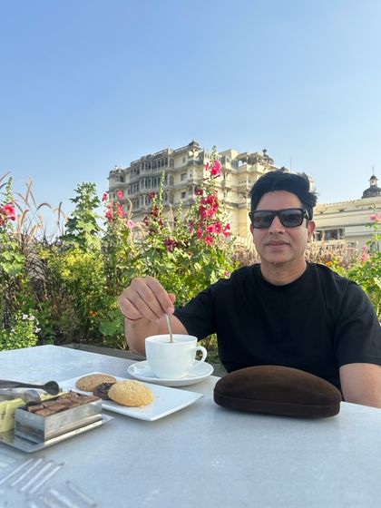 Enjoying a cup of tea with a view of a Udaipur palace. These quiet moments of reflection are just as important as the high-energy party nights.