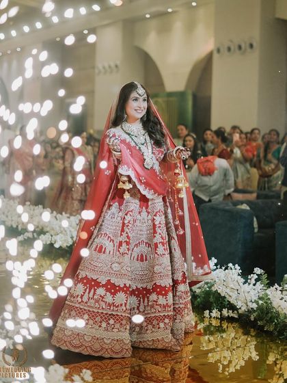 The bride's grand entrance, surrounded by sparklers. Her makeup catches the light beautifully, making her look absolutely magical.
