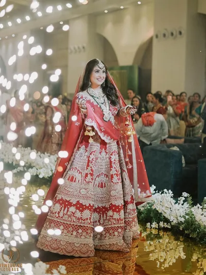 The bride's grand entrance, surrounded by sparklers. Her makeup catches the light beautifully, making her look absolutely magical.