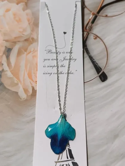 This unique pendant was made from a single, large blue orchid petal. Its natural shape and vibrant color are perfectly captured in the clear resin.
