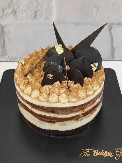 Our Tiramisu cake, decorated with chocolate shards and a touch of gold leaf for an extra luxurious finish.
