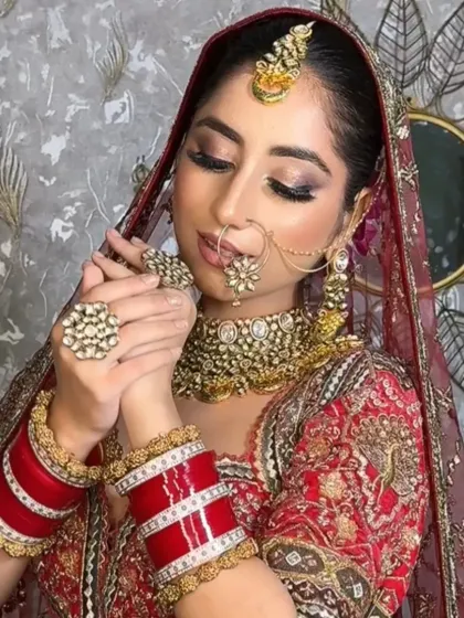 This bride is playing with her nose ring, giving a glimpse of her intricate jewelry and the soft, glowing makeup that complements it perfectly.