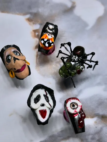 A flat lay of my spooky, hand-sculpted Halloween competition nails. Each nail is a miniature work of art, from the bloody eyeball to the creepy-crawly spider.