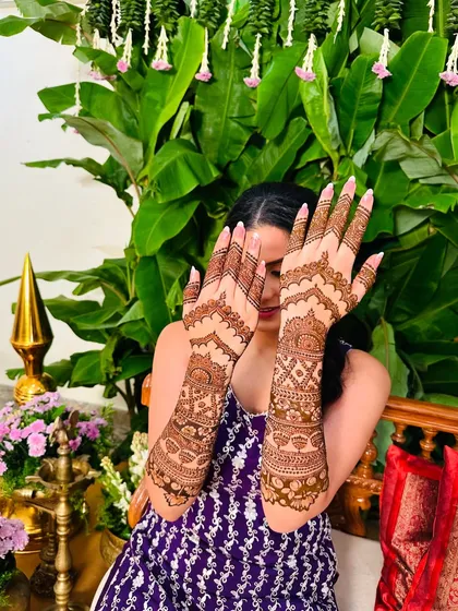 A beautiful example of symmetrical design, where the patterns on both hands create a complete picture, showcasing detailed work up to the elbows.