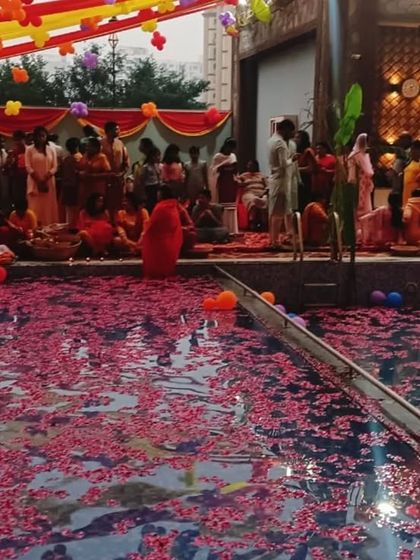 Residents gather by the poolside for Chhath Pooja. The water, adorned with flower petals, created a serene and beautiful atmosphere for this important festival.
