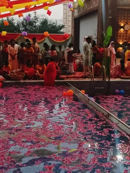 Residents gather by the poolside for Chhath Pooja. The water, adorned with flower petals, created a serene and beautiful atmosphere for this important festival.