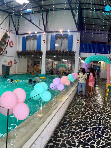 A wide view of a mermaid-themed party setup, showing how the decorations extend across the poolside, creating a cohesive and festive environment.