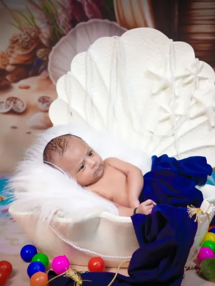 An "under the sea" themed newborn shoot. The baby is nestled in a large seashell prop, creating a whimsical and unique first portrait.