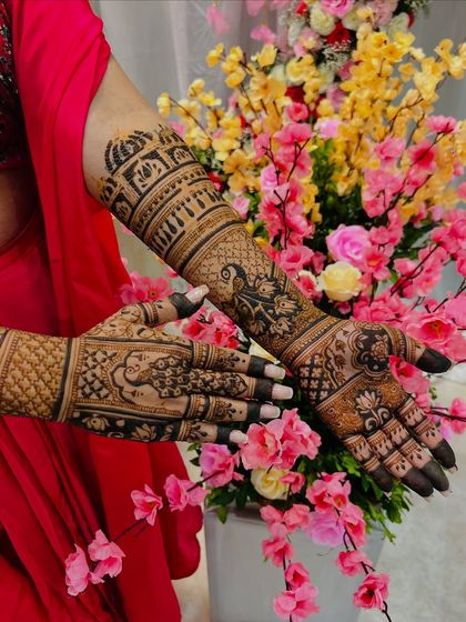 A beautiful shot of an engagement mehendi, featuring architectural dome motifs and peacocks. The design extends gracefully up the arm, creating a look that is both regal and celebratory.