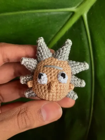 A close-up of the Rick Sanchez amigurumi. Capturing his wild hair and perpetually unimpressed expression was the best part of this custom character project.