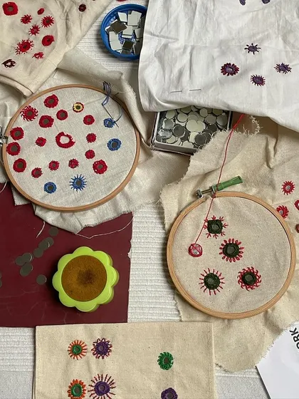 A collection of mirror work samples in progress. Students learn different techniques for framing the shisha mirrors with colorful threads, adding a festive sparkle to any textile.