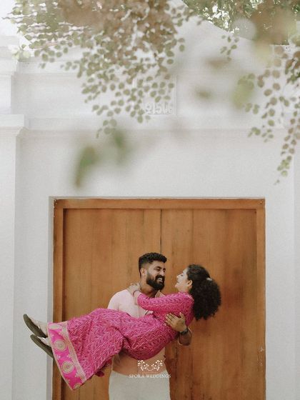 A joyful, spontaneous moment as the groom lifts his bride into his arms.