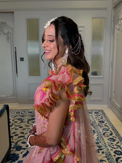 A playful Haldi look for Tanvi. We added glistening stones on her eyes for a touch of sparkle, complementing her bright pink and yellow outfit.
