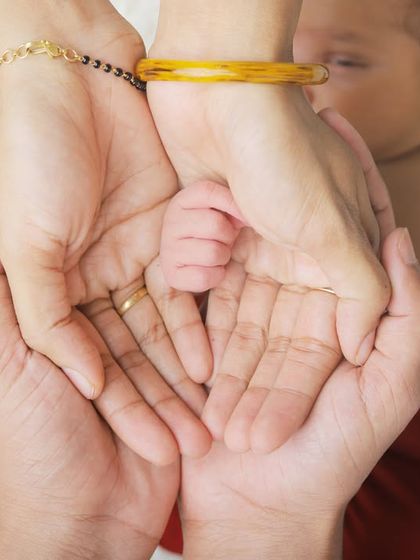 The tiniest hand held safely in the palms of its parents. This close-up shot focuses on the connection and love that surrounds a new baby, a simple and beautiful family portrait.