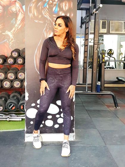 A full-body shot showing the dumbbell rack and gym floor at M R Fitness Zone in Delhi.
