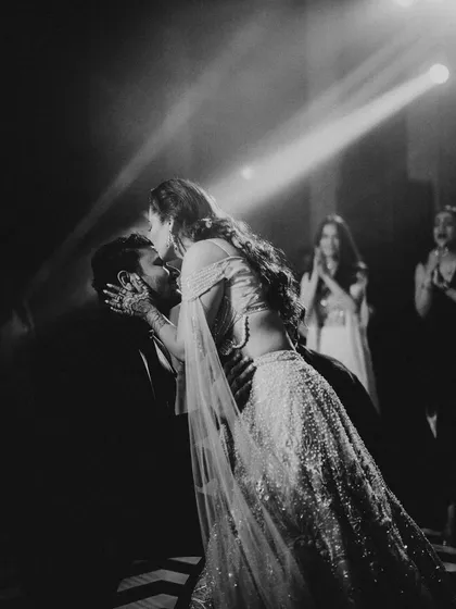 A beautiful, dramatic dip on the dance floor. This black and white shot, with its strong lighting, captures a peak moment of romance and celebration during the reception.