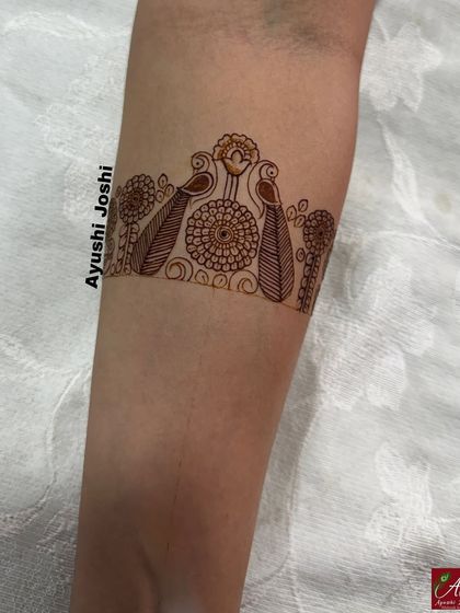 The simple outline for an engagement mehendi band, featuring peacocks and floral elements. This is a great example of a basic structure for a non-bridal design.