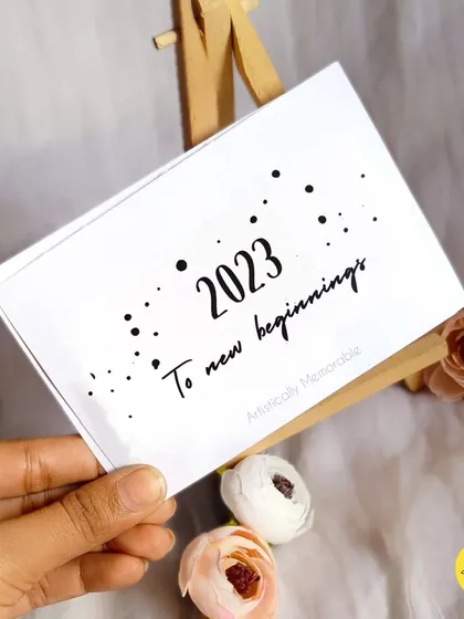 Holding the 2023 cover card. The design is clean, modern, and focuses on the year ahead.