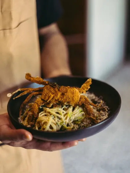 If pasta could talk, this one would tell you stories of long drives by the sea. Fresh linguine is tossed with roasted chilli and garlic olive oil, then crowned with a crispy soft-shell crab. It tastes like somewhere far away, yet deeply familiar.