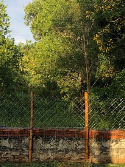 The finished Gabion compound wall at Cheerville, blending seamlessly into the landscape. The layers of stone and brick create a rustic, durable barrier that is both functional and visually striking.