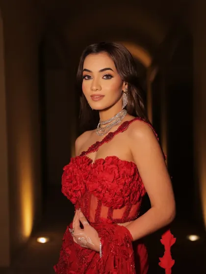 A beautiful portrait in a softly lit hallway. The styling of this red gown is designed to look glamorous and elegant in any setting.