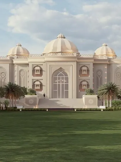A wider perspective of the banquet hall shows the main structure flanked by colonnaded wings, set across a vast, manicured lawn. The symmetrical and grand layout is designed to evoke the feeling of entering a royal estate, making any event an unforgettable experience.