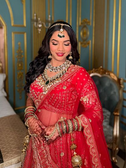 The complete bridal look for Pragati. We paired a traditional red outfit with classic makeup, focusing on defined eyes and a radiant complexion.