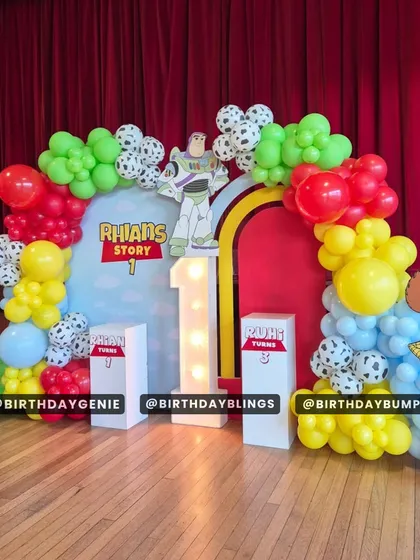 "To infinity and beyond!" This Toy Story first birthday party features a full stage with cutouts of Woody and Buzz Lightyear. The cloud-print backdrop and cow-print balloons bring Andy's room to life.