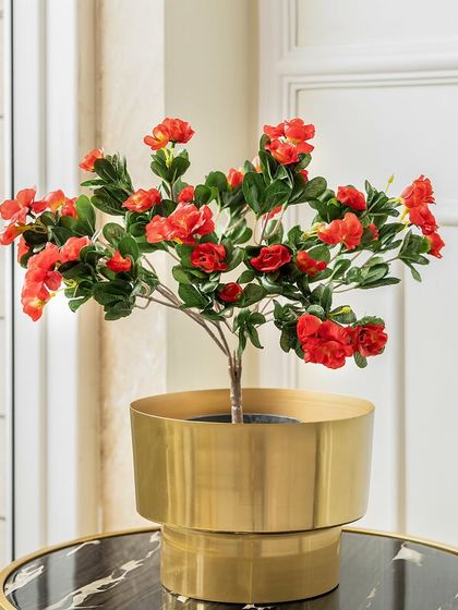 These small, vibrant red artificial spring blooms are perfect for tabletop arrangements. Placed in a modern brass planter, they add a cheerful pop of color to a side table or desk.