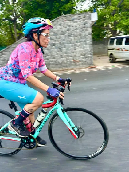 A rider in a bright pink and blue kit, captured in motion.