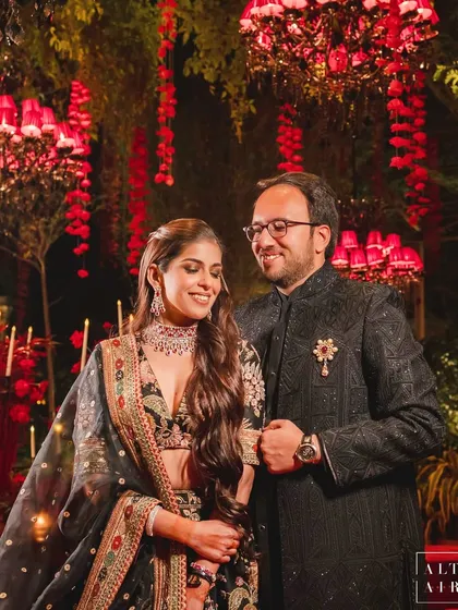 The beautiful couple, Dipin and Jatin, amidst the romantic red glow of their 'Laal Bagh' celebration. My greatest joy is creating a world that not only looks beautiful but also feels like the perfect reflection of a couple's love.