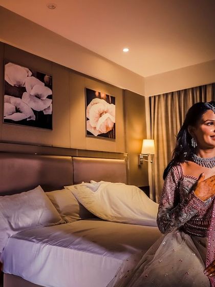 A wide shot of a woman in a hotel room, using the ambient light to create a calm and composed portrait.