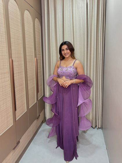 A happy and confident pose in this stunning purple outfit. The color is rich and royal, and the modern design makes it a fun and stylish choice for the festive season.