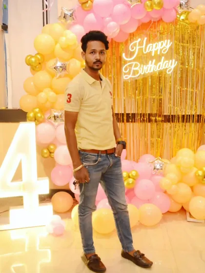 A photo of me with one of my creations, a pink and yellow ring decoration for a 4th birthday.