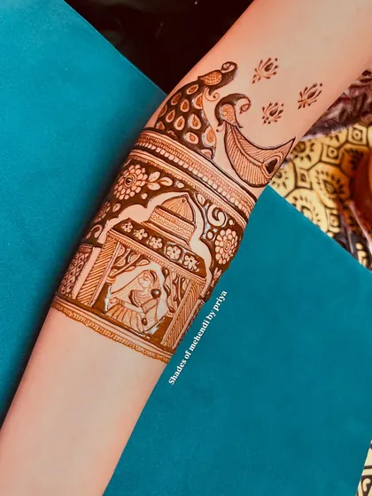 A close-up of a wedding ritual scene on the forearm. This depicts a part of the ceremony inside a beautifully decorated mandap, with peacocks adding a touch of grace.