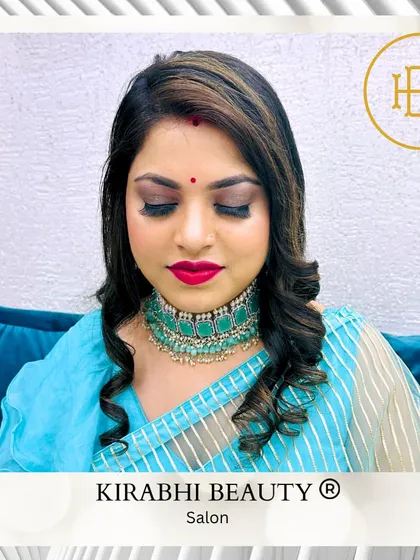 A classic party makeup look with a smokey eye, bold red lip, and perfectly defined brows. Her hair is styled in soft curls to complete the glamorous look.