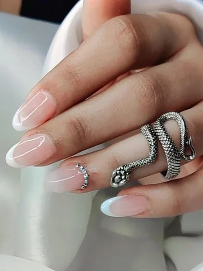 An elegant French manicure with a subtle ombré base, accented with a delicate curve of rhinestones on the ring finger.