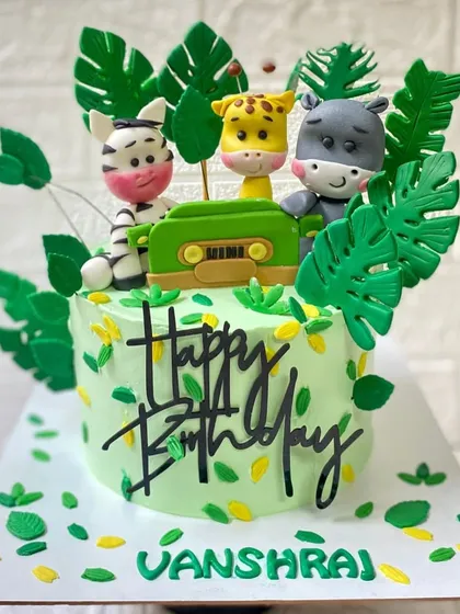 Welcome to the jungle. This chocolate cake features a modern design with fondant animals, a retro radio, and tropical leaves.