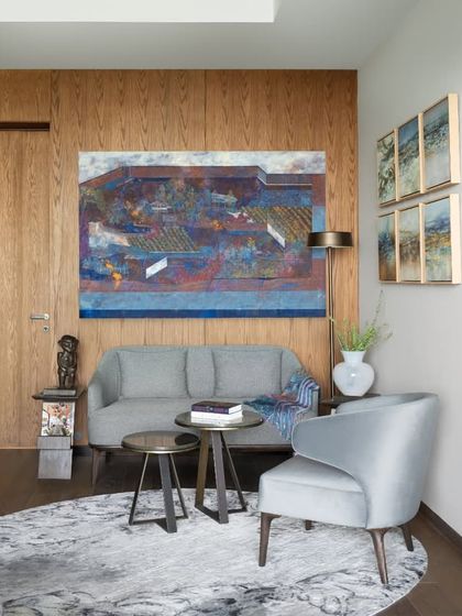 A cozy seating nook within a guest bedroom in the DLF Camellias apartment. We believe in creating these smaller, intimate zones even within larger rooms, providing a quiet corner for reading or conversation.