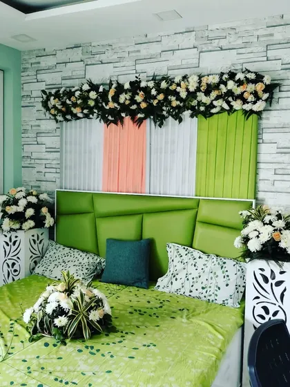 A simple and elegant first-night room decoration. The headboard is decorated with drapes and flowers, and floral bouquets are placed around the room to create a fresh and romantic feel.