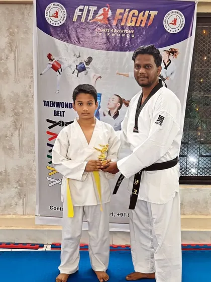A student receives his trophy from the chief guest, a moment of pride for him and the academy.