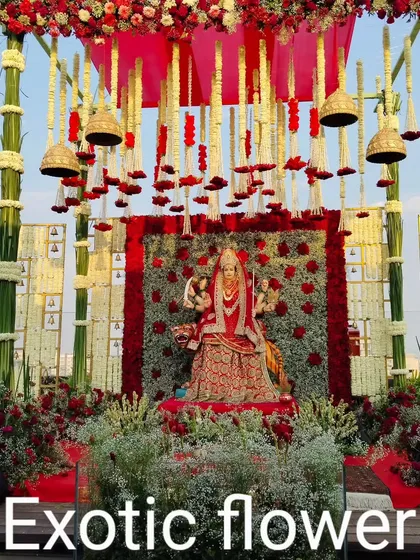 For this grand outdoor festival, we designed a majestic mandap for a Devi idol using bamboo structures, rich red fabrics, and thousands of roses and baby's breath. The hanging temple bells and multi-level floral arrangements create an immersive and spiritually uplifting atmosphere.
