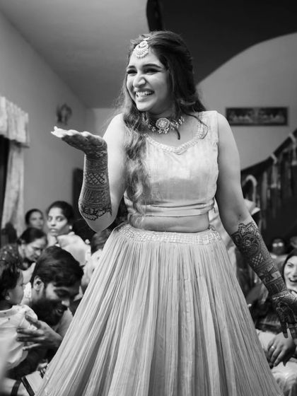 A happy black and white photo capturing the joy of the celebration. The focus is on her radiant smile and the fun atmosphere.
