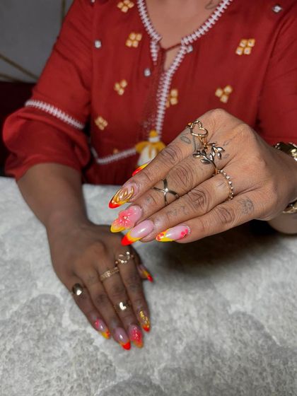 A fiery ombre set with yellow and red tips, accented with gold flakes and 3D elements. This design is for clients who aren't afraid to stand out.