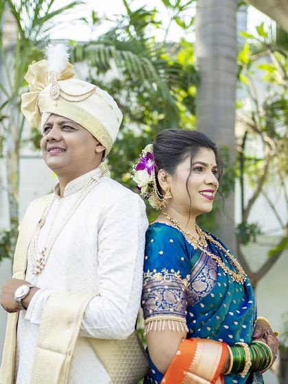A classic back-to-back pose, showcasing the couple's beautiful traditional wedding outfits.