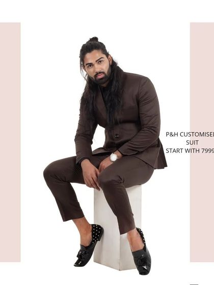 A seated pose in the brown suit, demonstrating the comfort and style of the tailored fit.