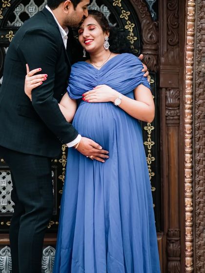 A loving couple's portrait taken against an ornate, traditional doorway. This type of location adds a touch of grandeur and architectural beauty to your outdoor maternity photos.