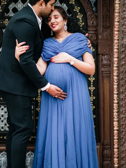 A loving couple's portrait taken against an ornate, traditional doorway. This type of location adds a touch of grandeur and architectural beauty to your outdoor maternity photos.
