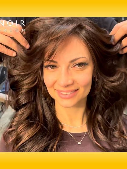 The smile of a happy client after her hair transformation. This rich, chocolate brown color with soft waves is a classic, elegant look.